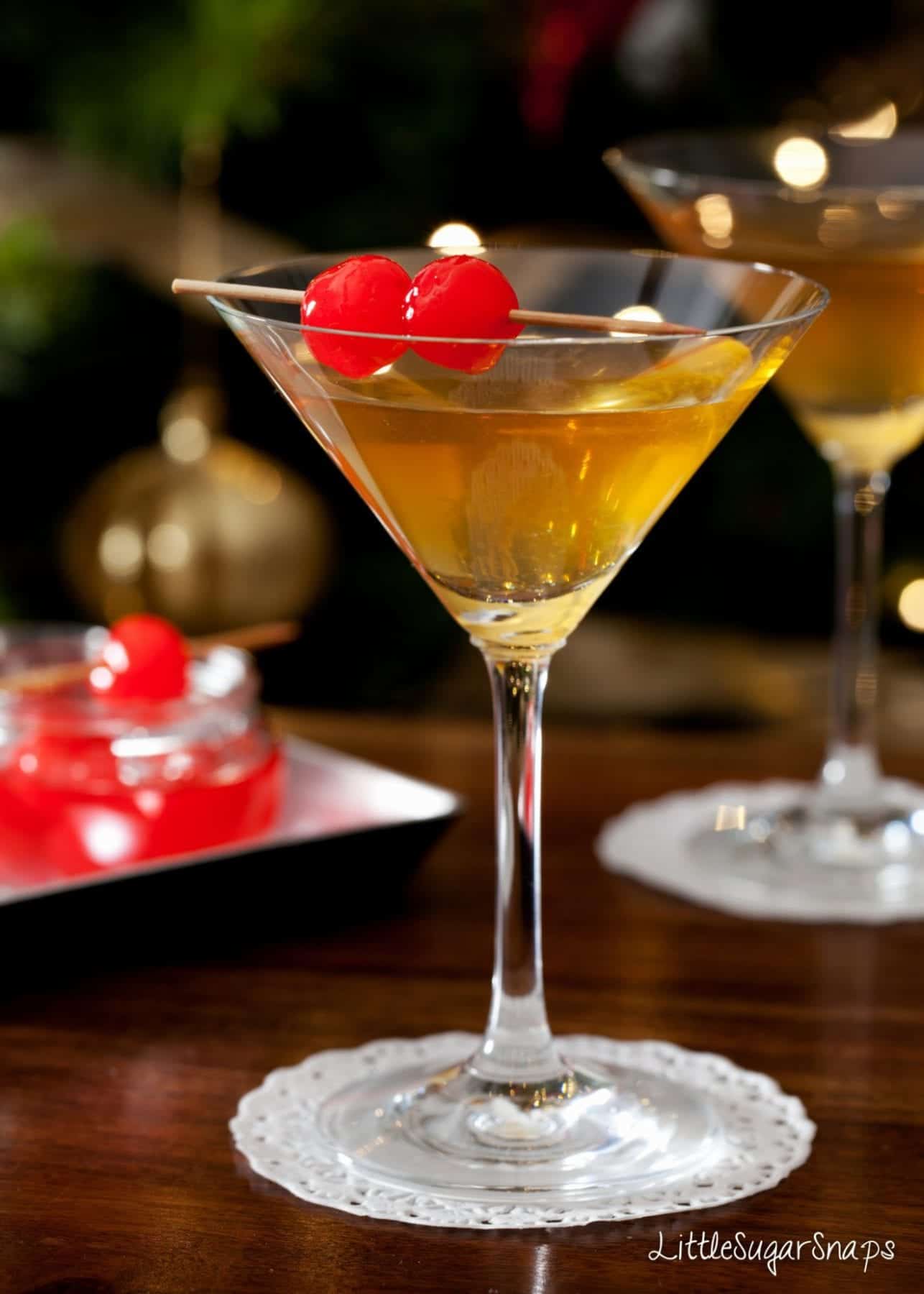 Amaretto martini garnished with maraschino cherries on a cocktail stick