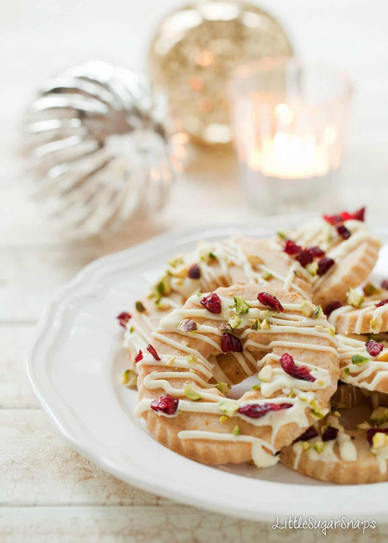 Christmas wreath cookies topped with chocolate drizzle, cranberries and pistachios