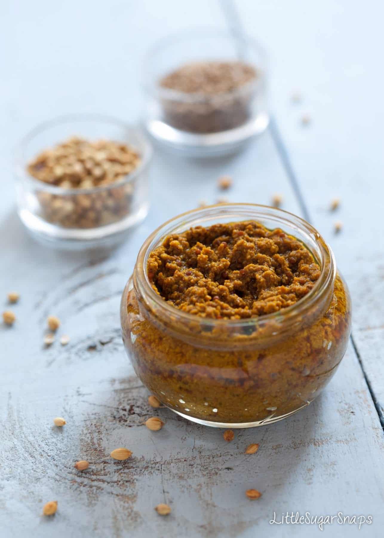 Homemade Madras Curry paste in a jar with coriander seeds