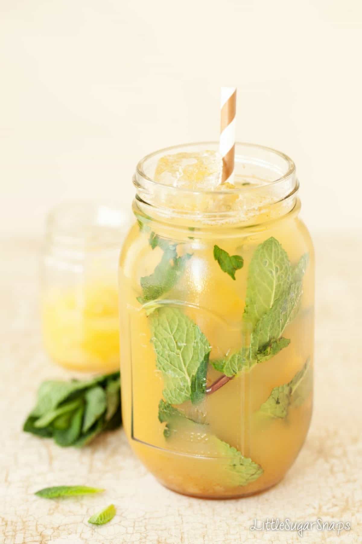 Bourbon Pineapple & Pear cocktail in a jam jar with a paper straw