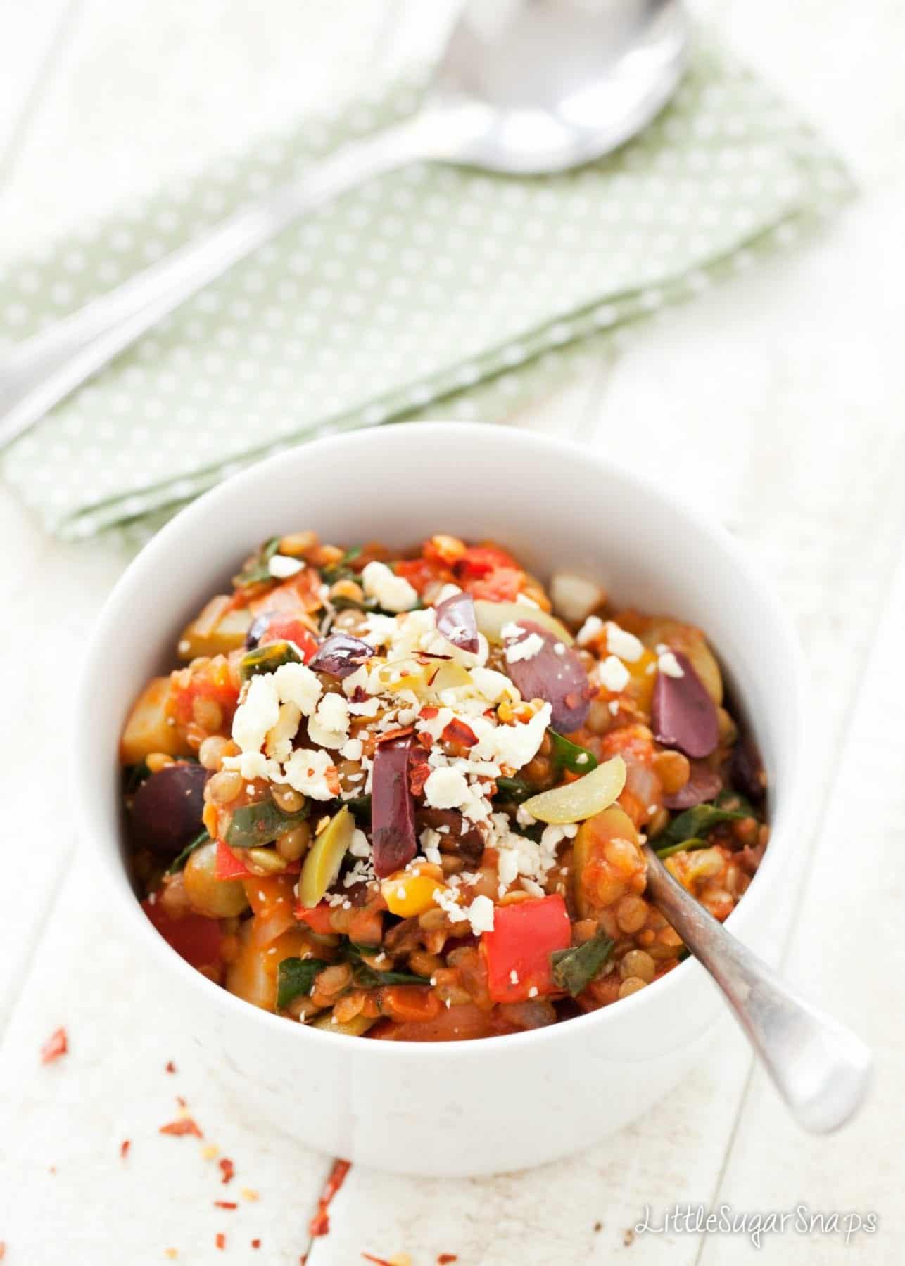 A bowl of Lentil Olive Stew with crumbled feta on top