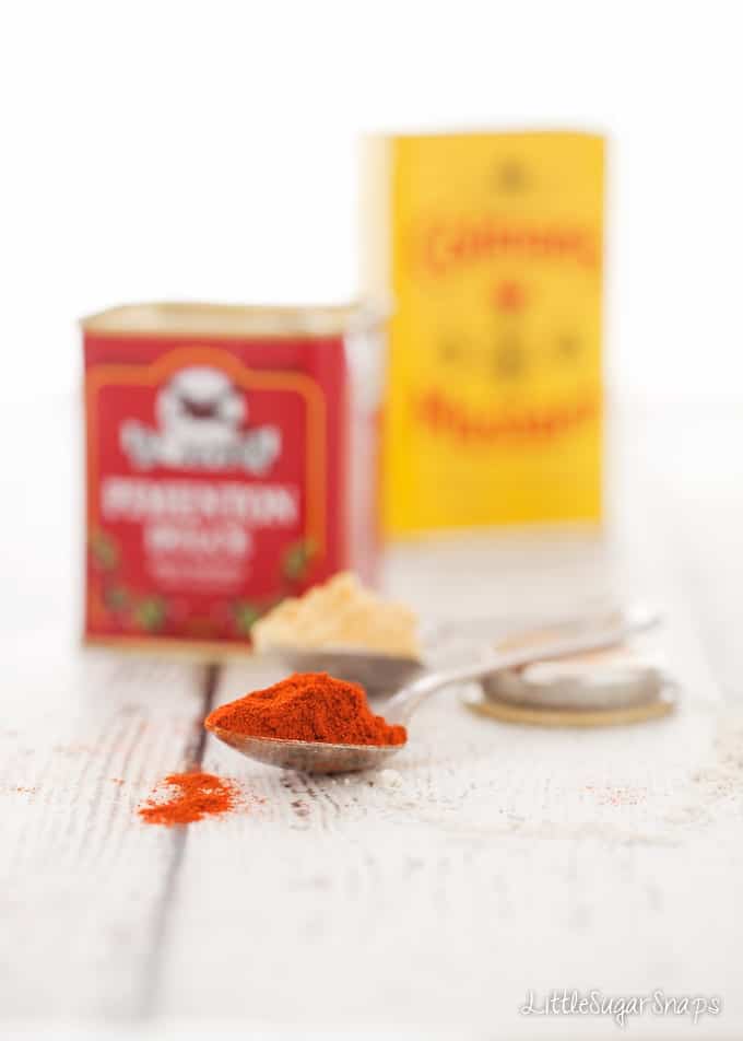 Ingredients - paprika and mustard powder on spoons with their jars behind