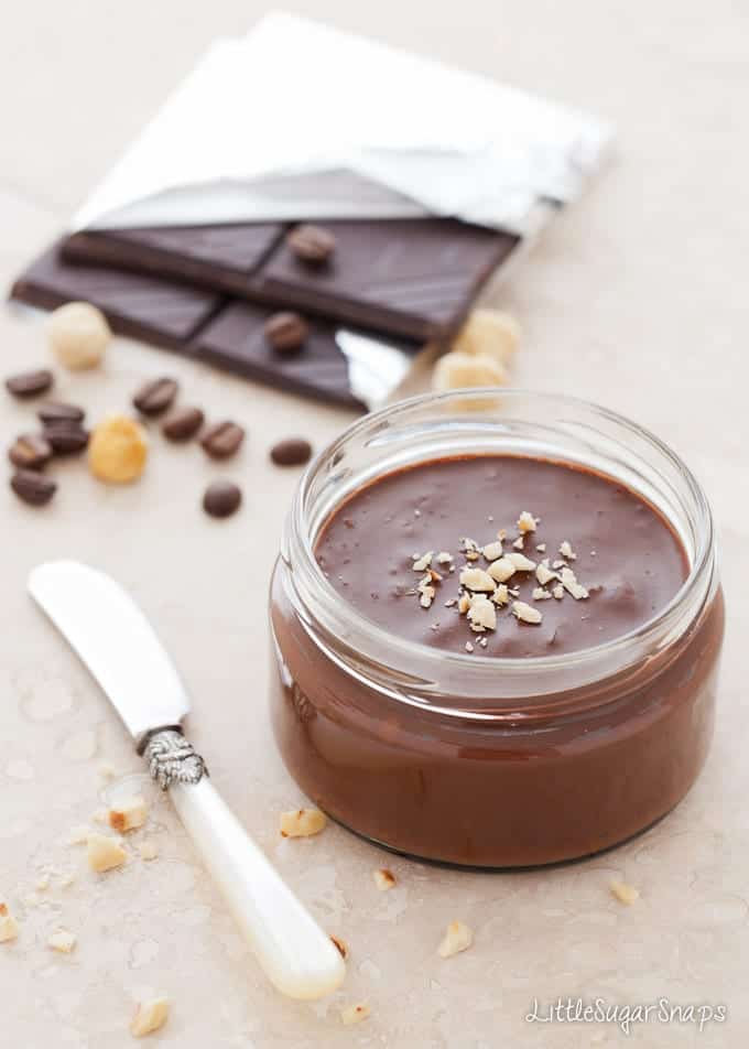 Jar of chocolate spread with ingredients behind it