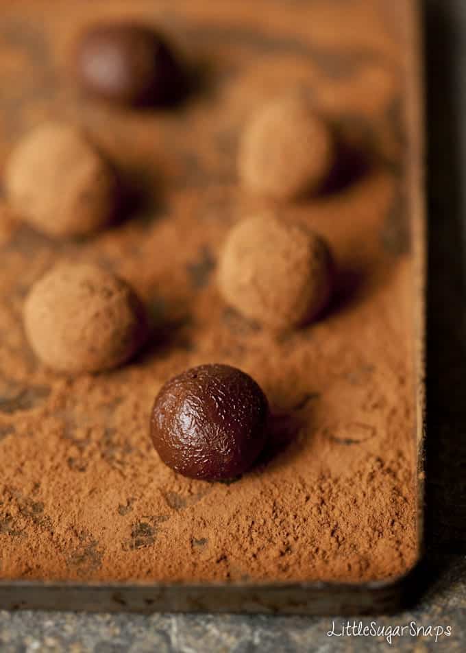 Making chocolate truffles by rolling them in cocoa powder