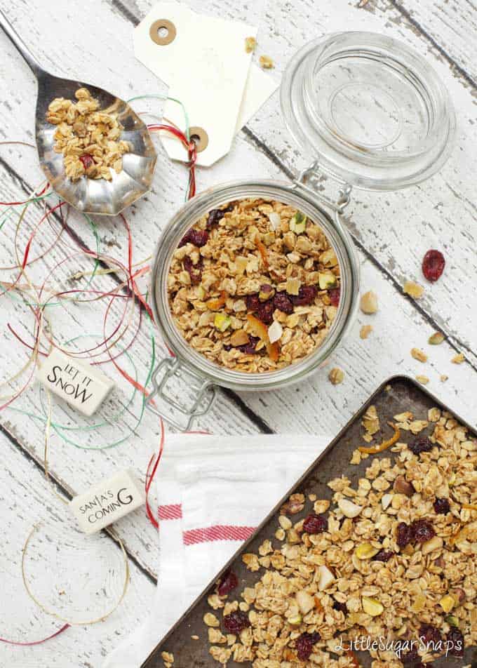 Christmas granola with Ginger & Cranberry being put into a jar