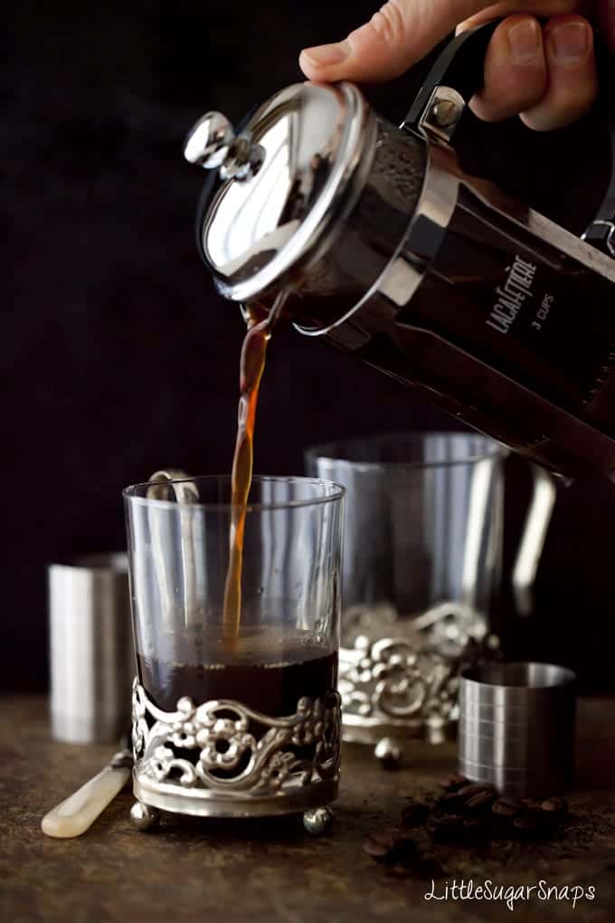 Coffee being poured from a cafetiere into vintage glasses