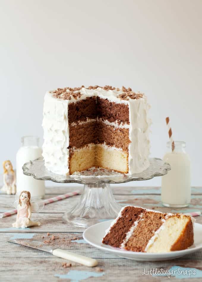 A cut open triple chocolate layer cake (white chocolate, malted milk chocolate and dark chocolate).