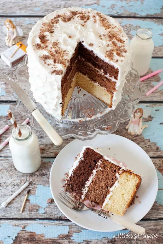 Triple Chocolate Layer Cake cut into with layers of white, milk and dark chocolate sponge