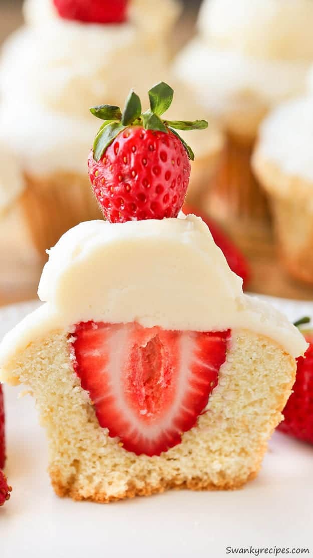 A Strawberry Shortcake Cupcake cut in half to reveal a strawberry in the centre