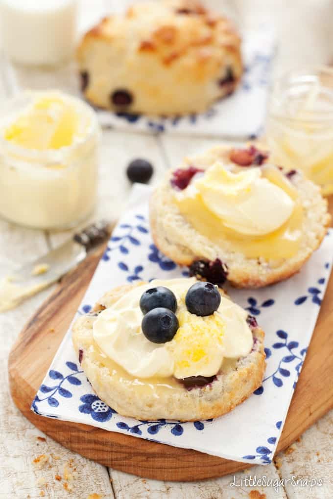 Halves of Blueberry Lemon Scones with lemon curd, clotted cream and blueberries