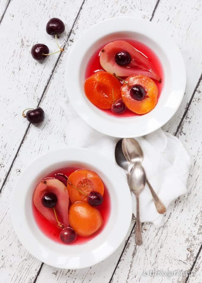 Bowls of Poached Fruit in cooking syrup including pears, cherries and apricots