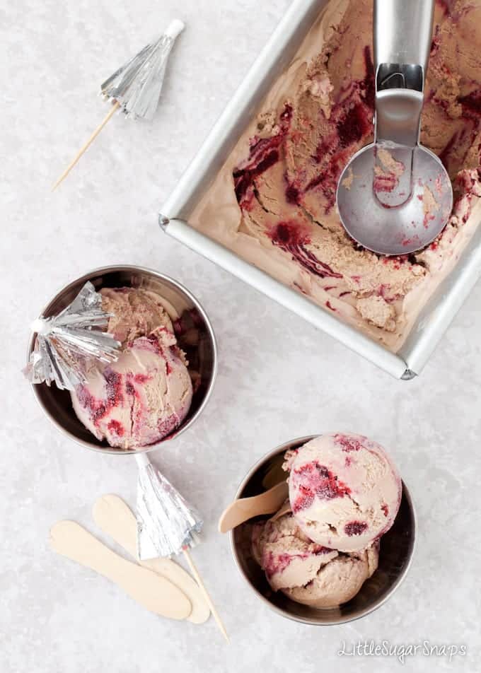 A metal tin and bowls containing Nutella Ice Cream with blackberry ripple