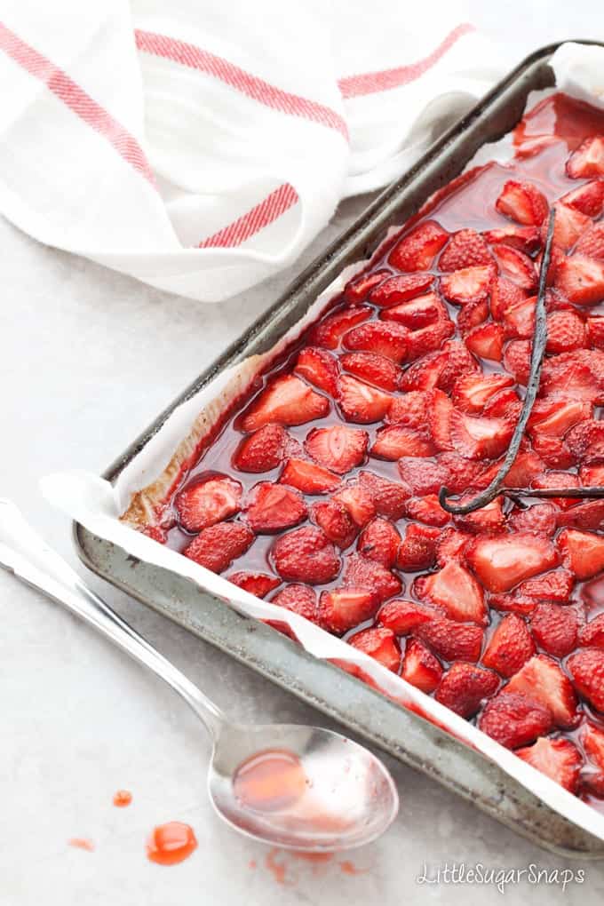 Roasted Strawberry Sauce on a baking sheet with vanilla pod on top.