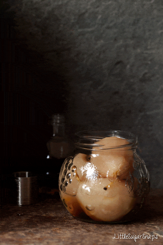 Gif of syrup being poured into a jar of poached pears with amaretto liqueur 