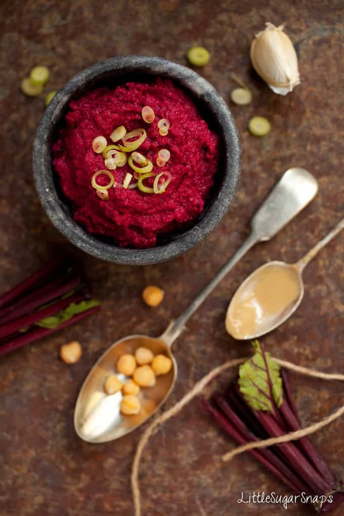 A bowl of Beetroot hummous with spring onion garnish