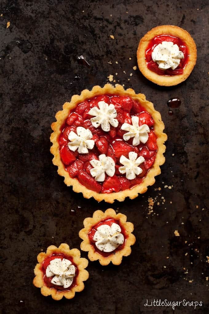 Strawberry Tarts topped with whipped cream and ground vanilla