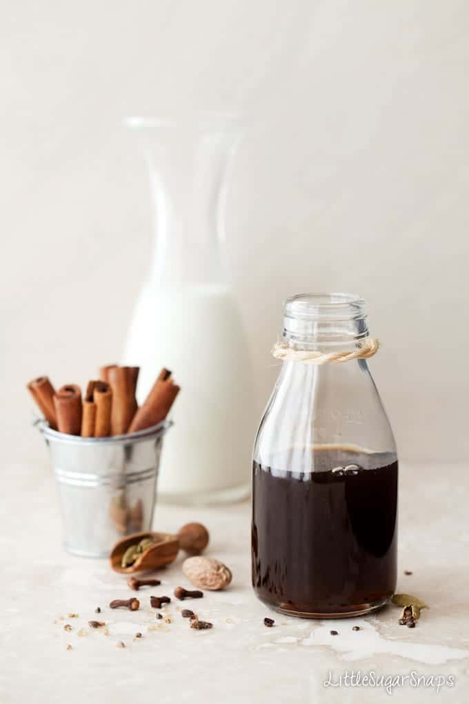 A bottle of Masala Chai Syrup next to spices.