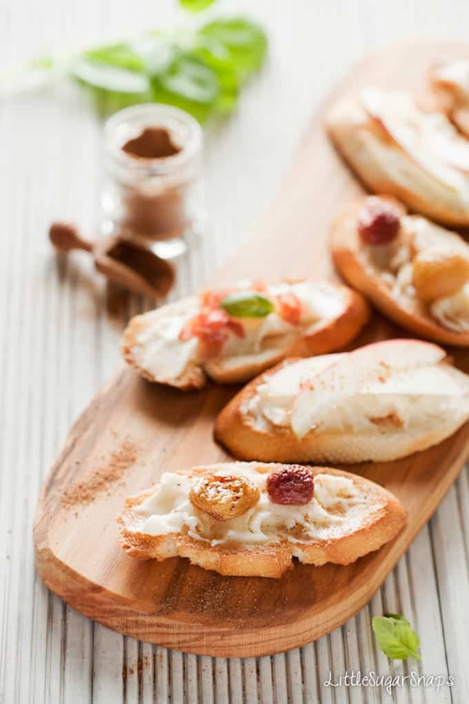 Taleggio Crostini on a wooden board with mixed toppings