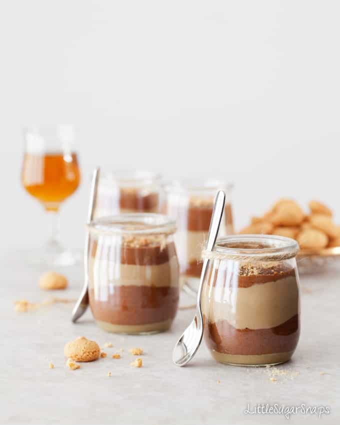 Layered chocolate, coffee and caramel desserts in glass jars