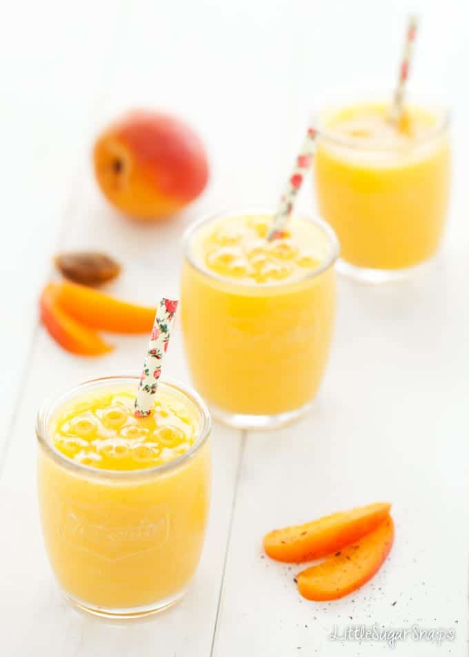 Three glasses of apricot smoothie in a diagonal row