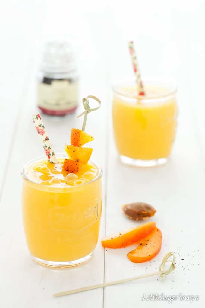 Glasses of Apricot Mango Smoothie with fresh apricot on a cocktail pick