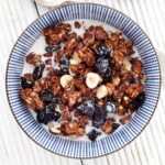 Healthy Chocolate Granola Recipe - a portion in a bowl with milk poured over it