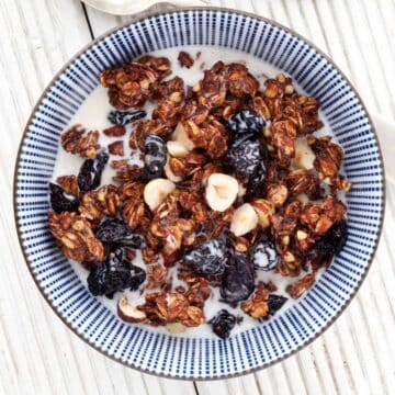 Healthy Chocolate Granola Recipe - a portion in a bowl with milk poured over it