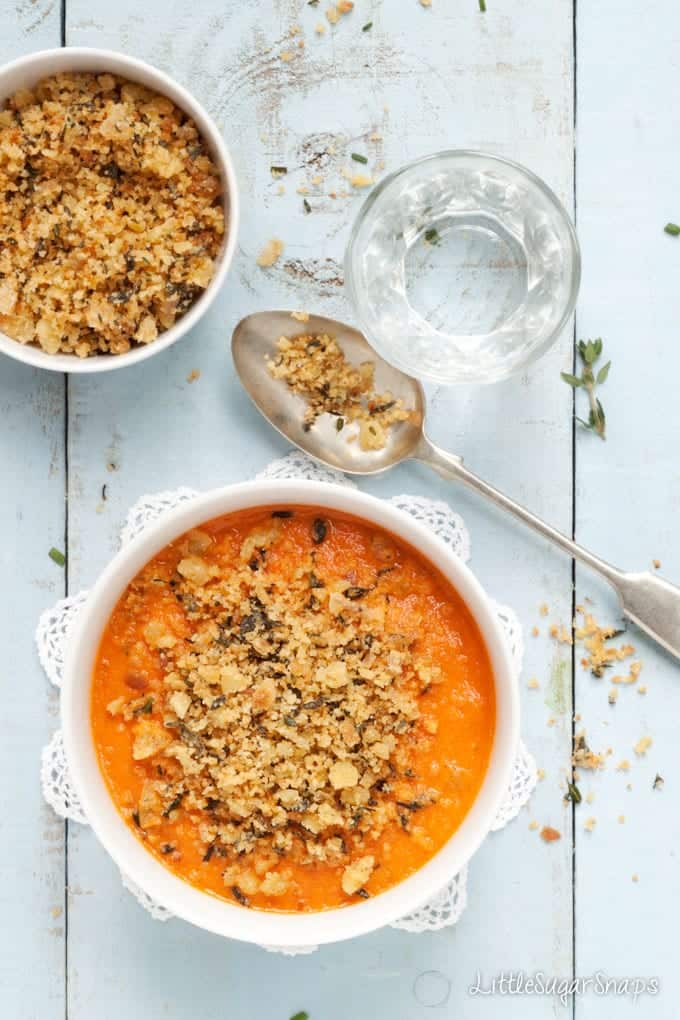 Bowls of tomato soup with herb breadcrumb garnish