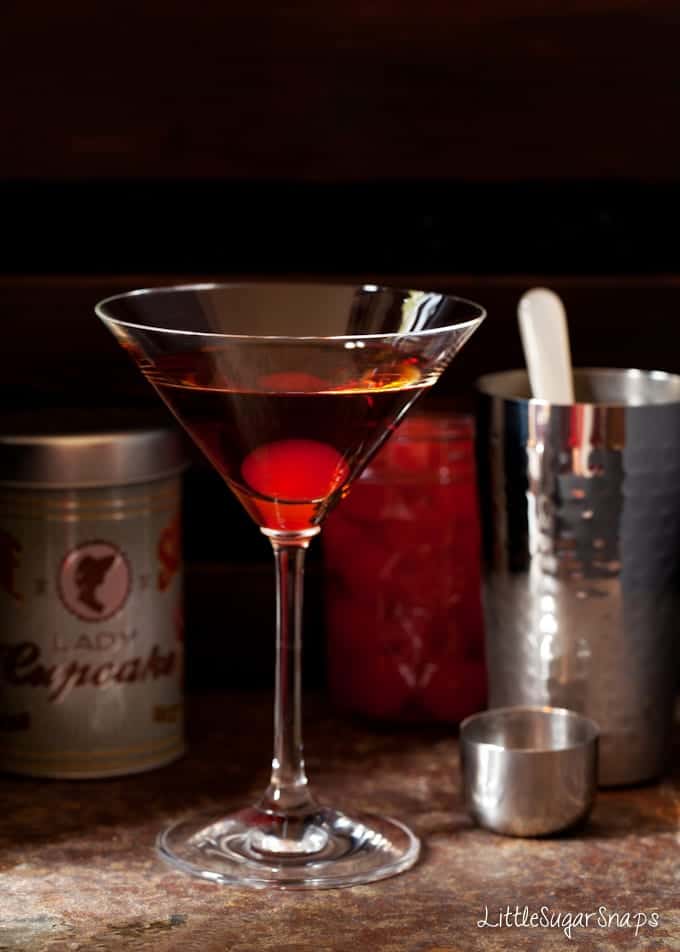 bourbon cocktail with a maraschino cherry in the glass