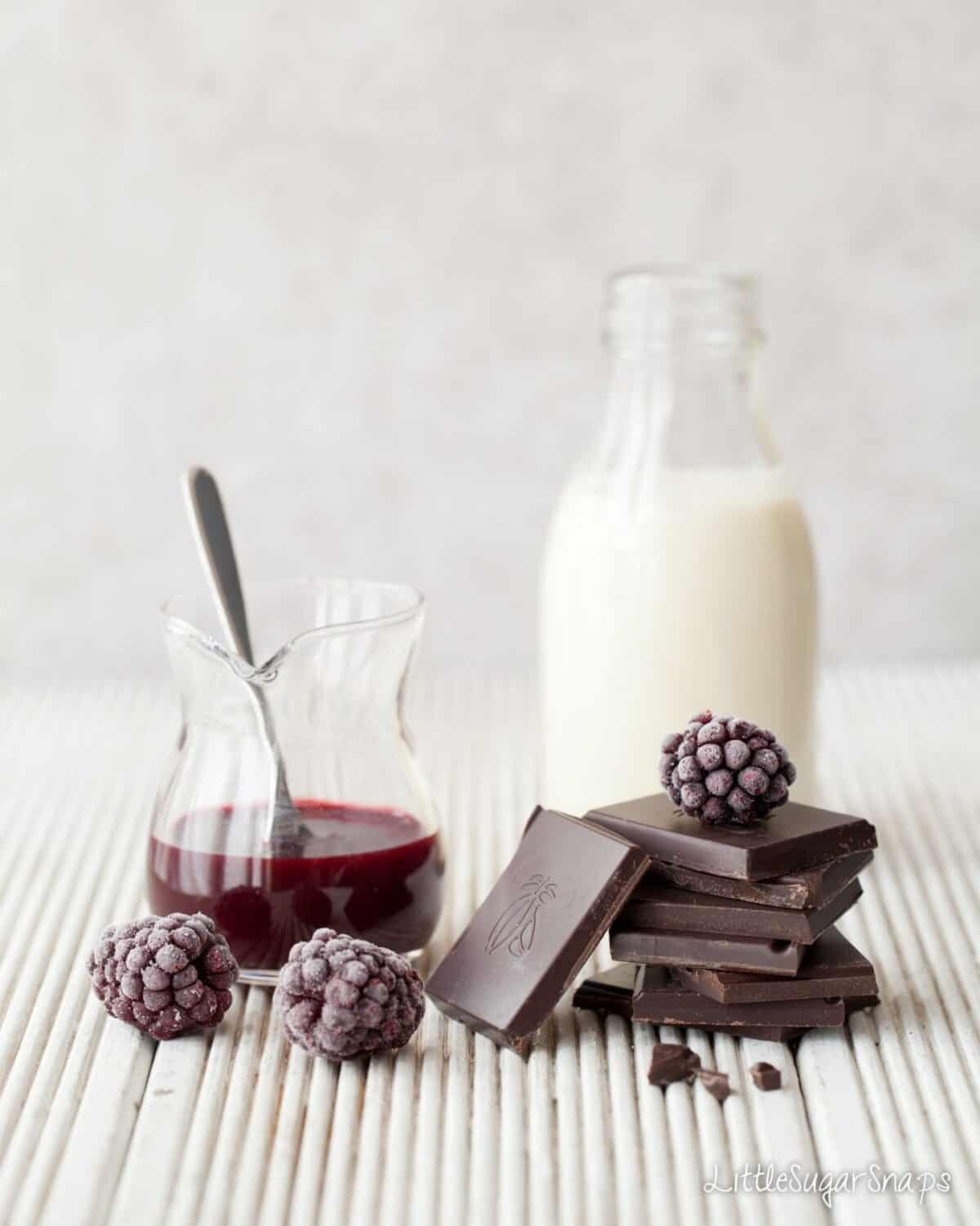 Hot chocolate ingredients: milk, dark chocolate blackberries and blackberry sauce.