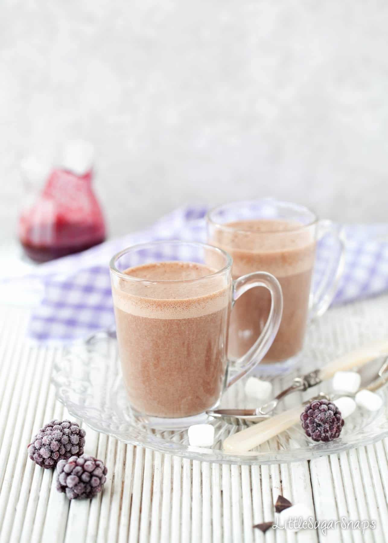 Glass mugs of Hot chocolate drink with a frothy top. 