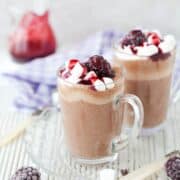 2 glasses of Blackberry Hot Chocolate with cream, coulis, marshmallows and blackberry