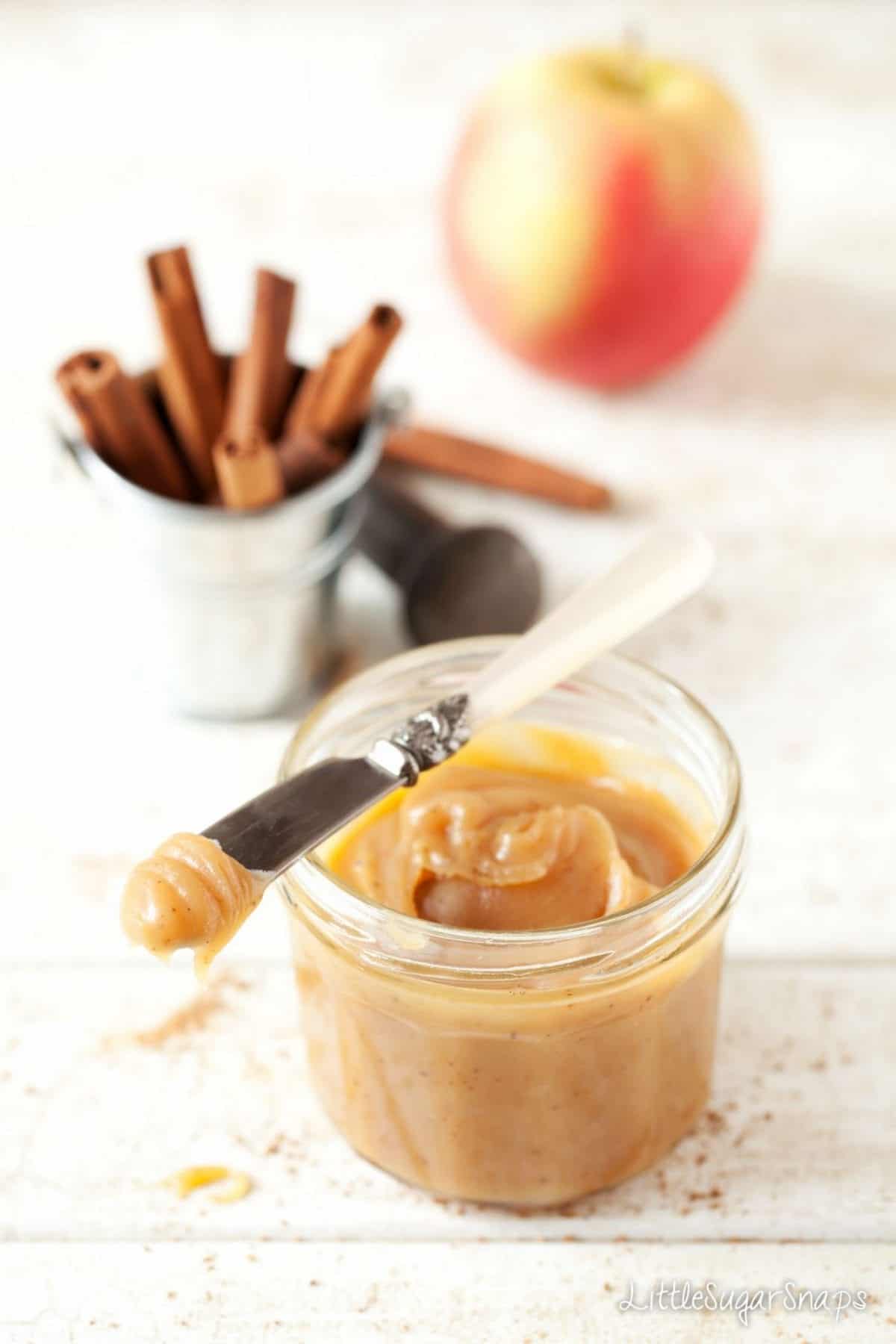 A jar of caramel apple dip with a vintage knife resting on the side.