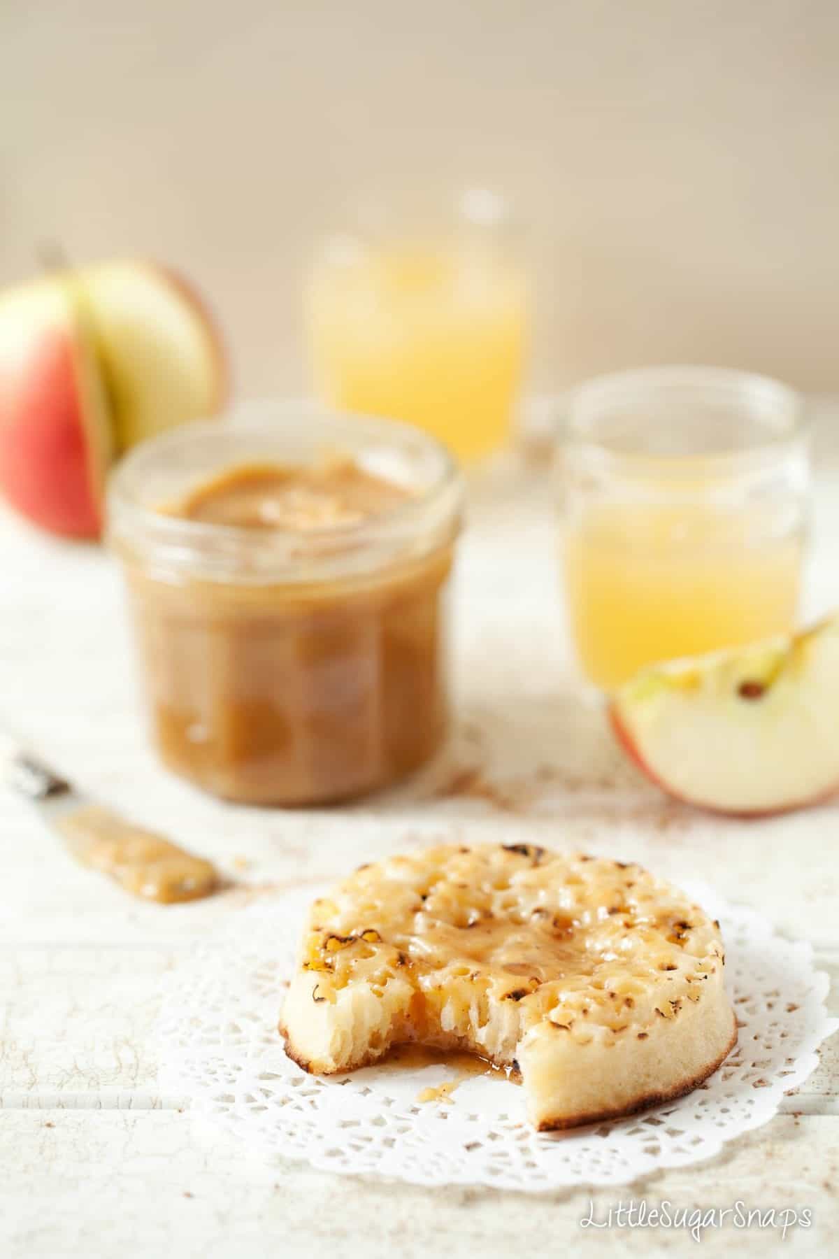 An English crumpet with a sweet sauce spread on it and a bite taken out