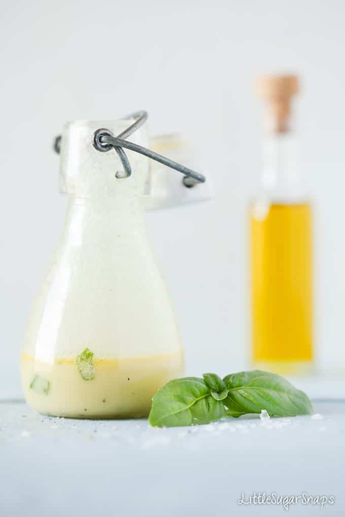 Basil Salad dressing in a jar with fresh basil next to it