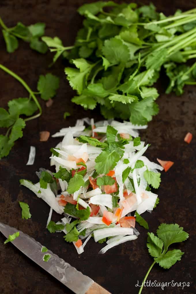 Onion salad with coriander & tomato on a worktop