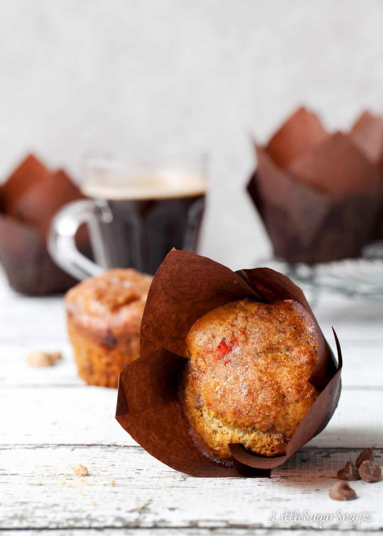 An Orange Drizzle Muffin on its side - still in a brown wrapper