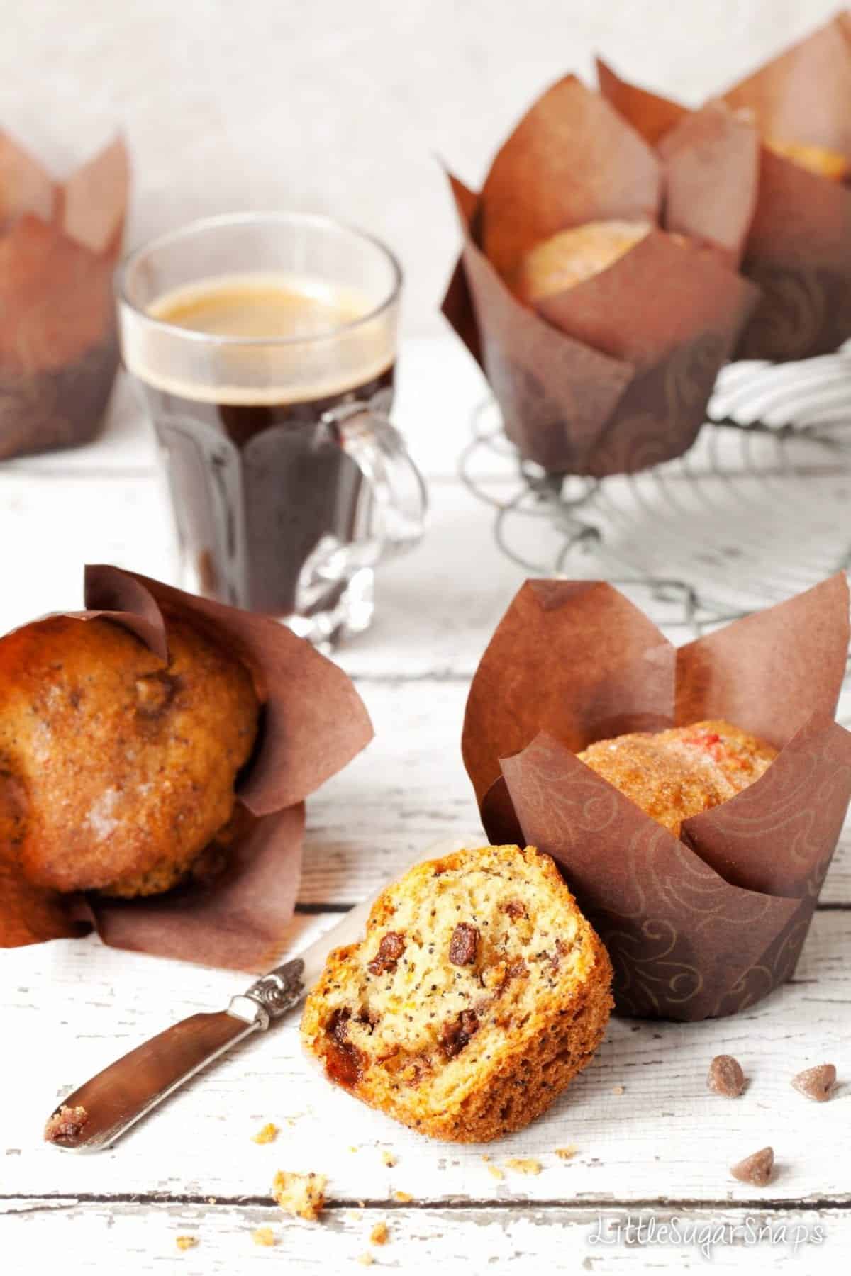 Chocolate orange muffins on a table with a cup of coffee.