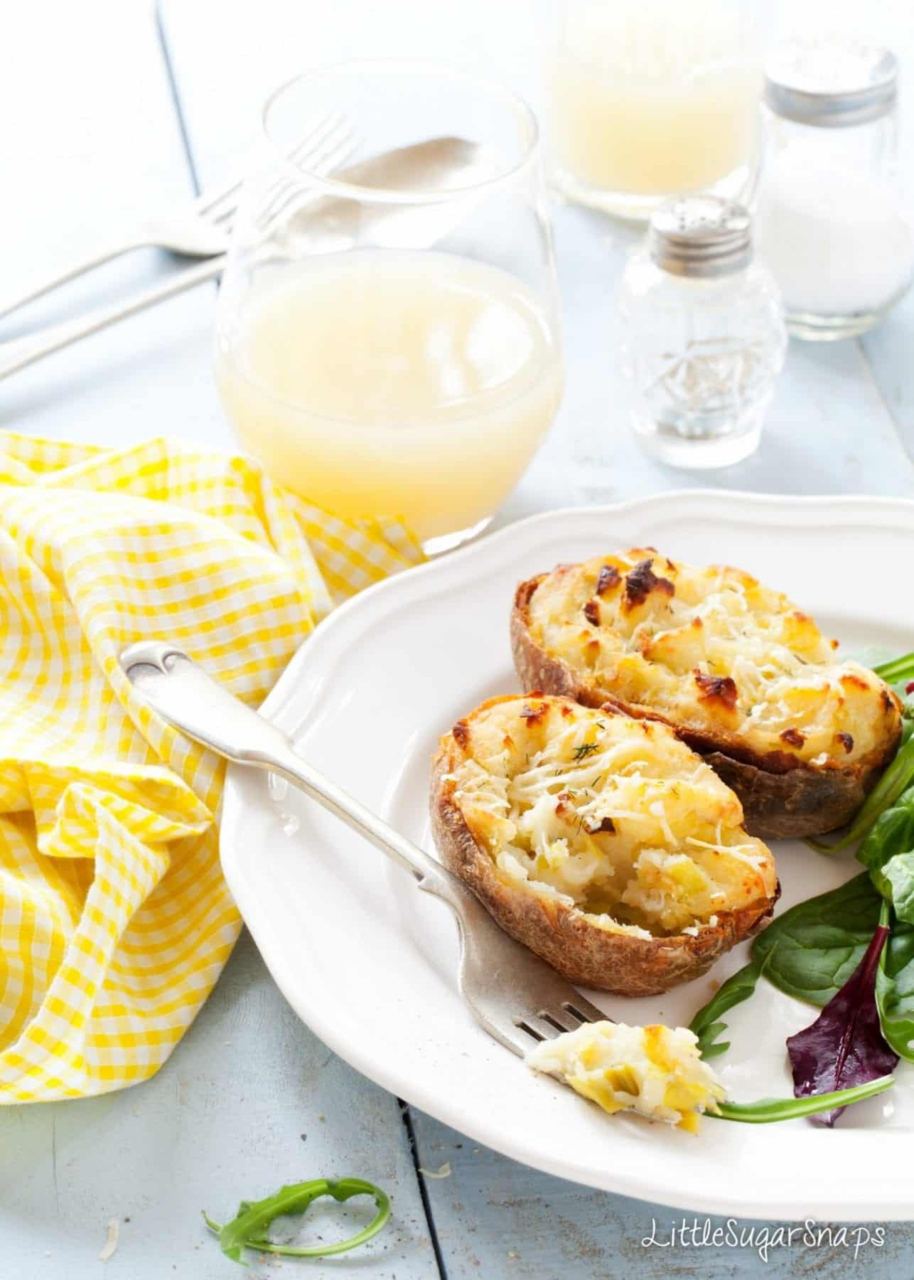 Cheesy Leek Baked Potato halves on a plate with salad.