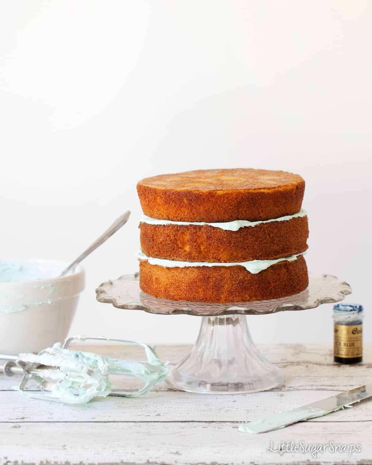 Assembling a white chocolate cake: sandwiching layers together with buttercream