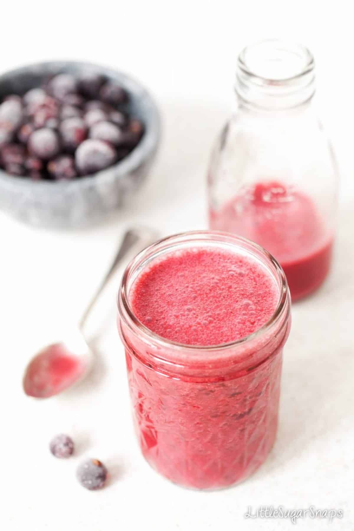 A pink smoothie in a jam jar glass 