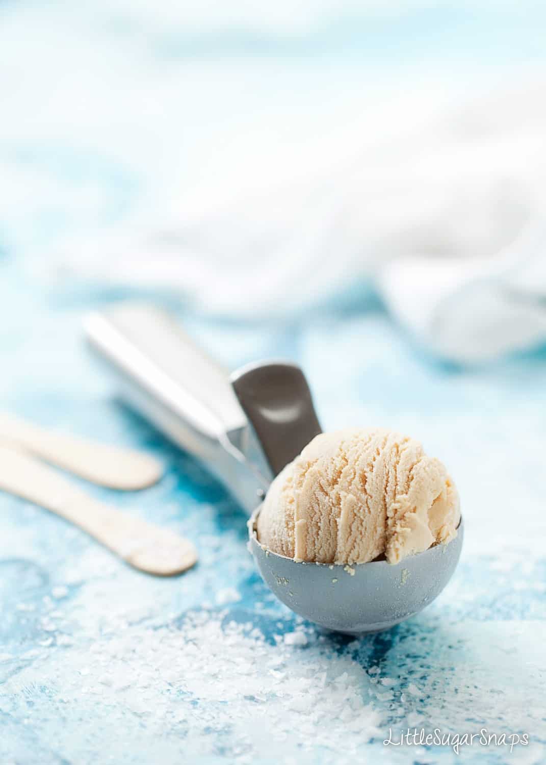 A ball of ice cream resting on an ice cream scoop
