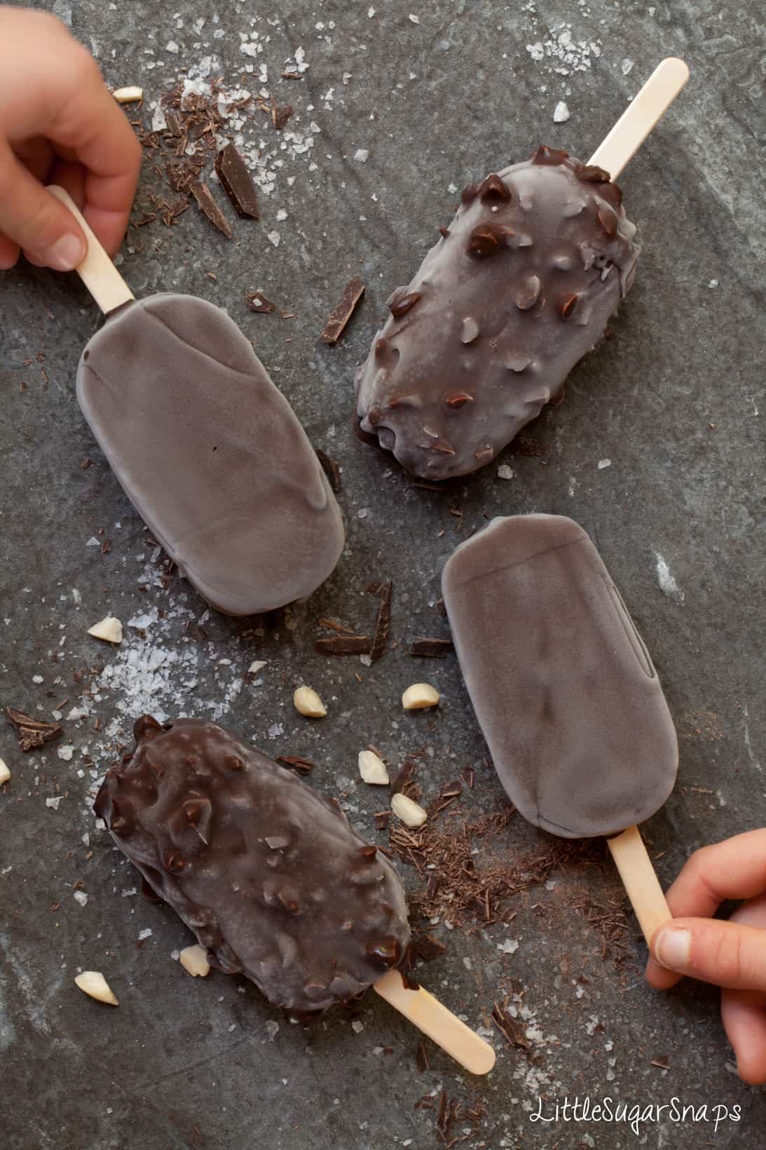 Children picking up ice Cream Bars covered in chocolate and nuts