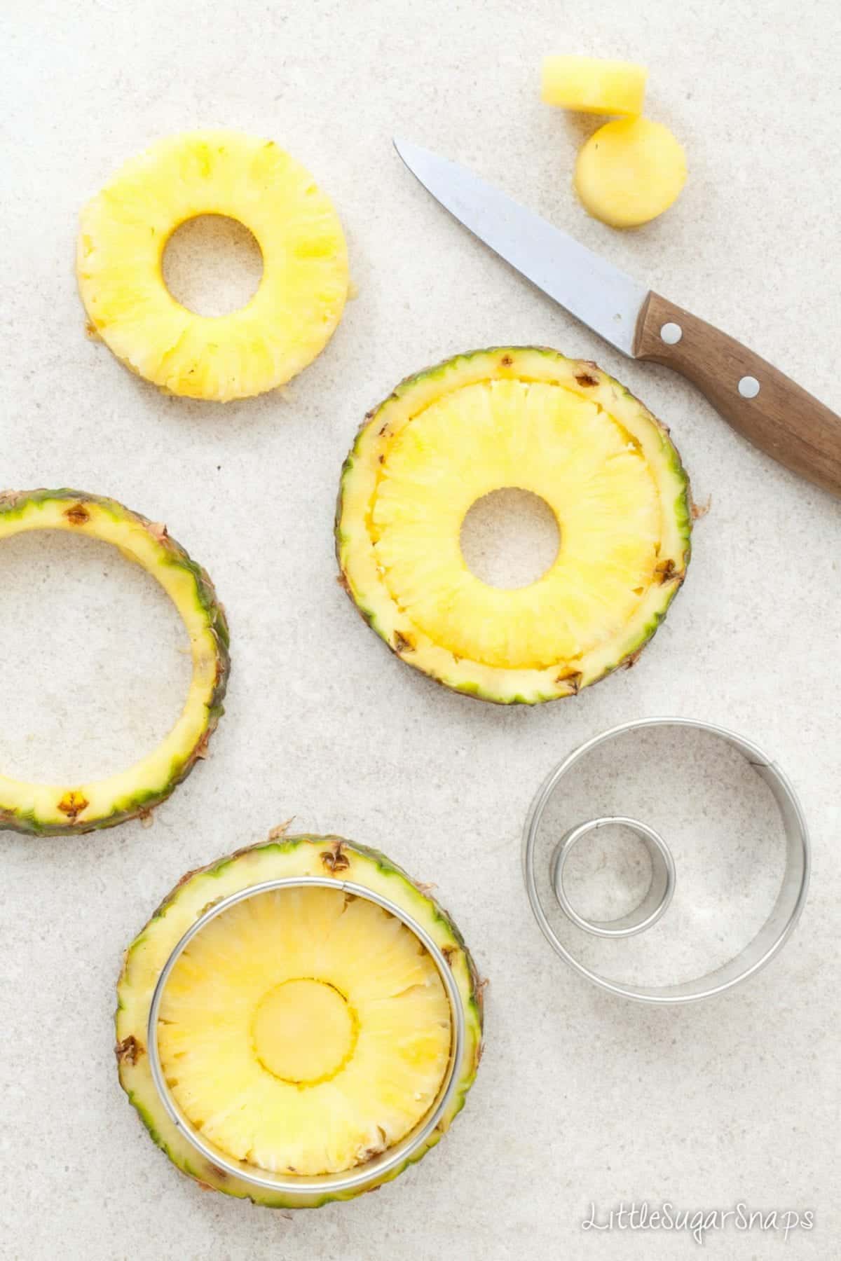Cutting fresh pineapple into rings using cookie cutters