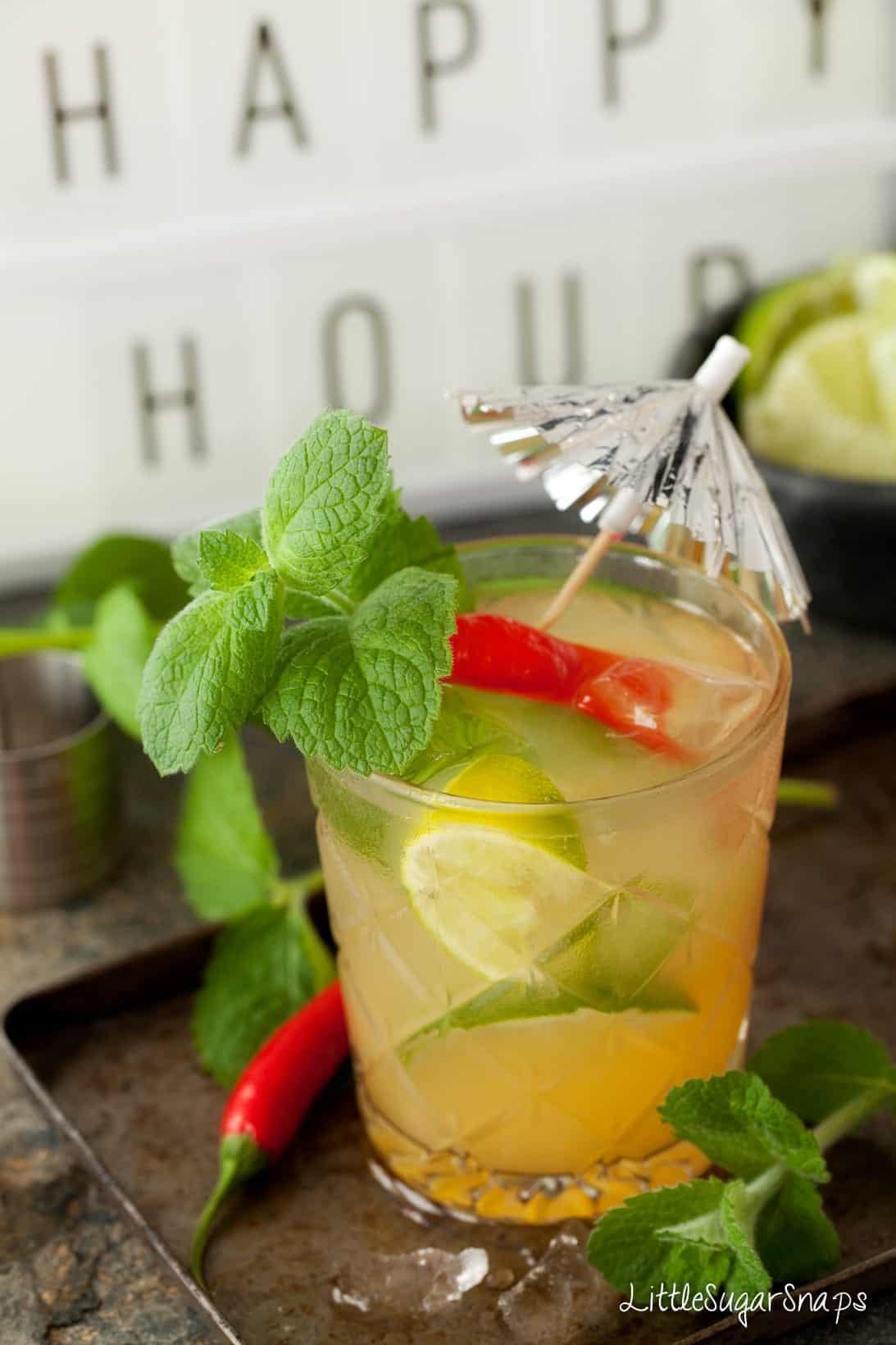 A cocktail made with chilli vodka decorated with red chilli, lime and lime.