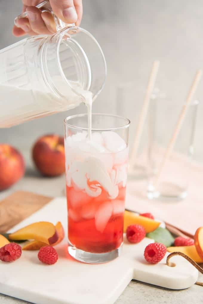 Person pouring a raspberry ice cream soda