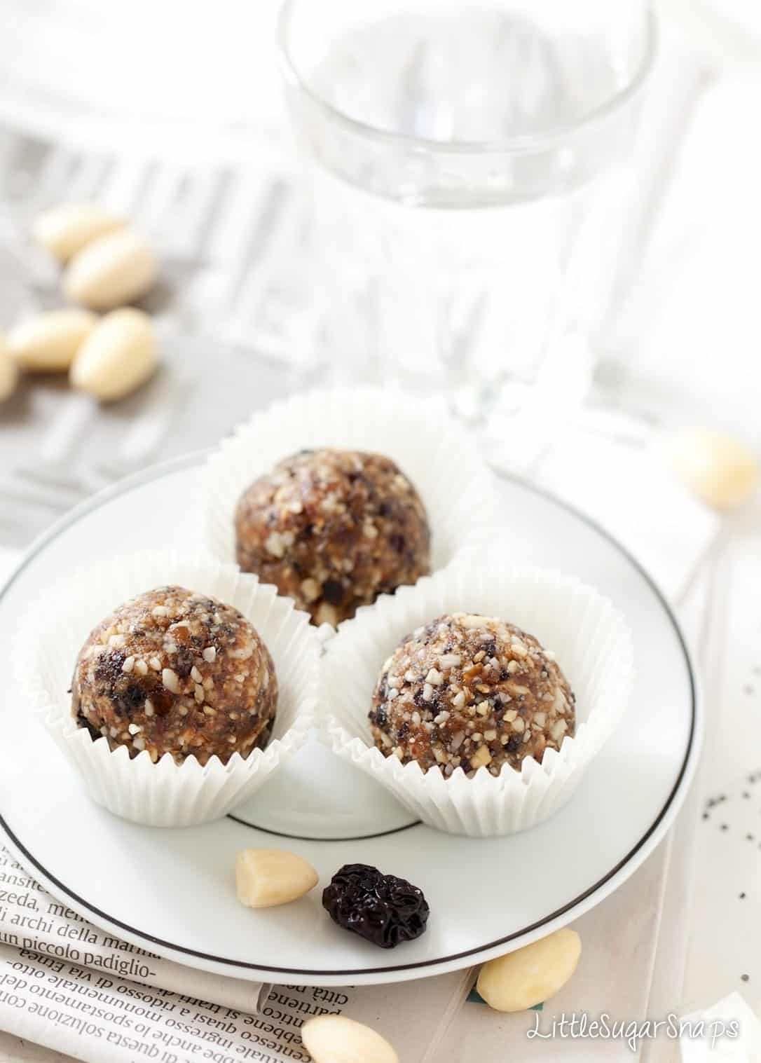 Three Cherry Bakewell Almond Energy Balls on a plate.