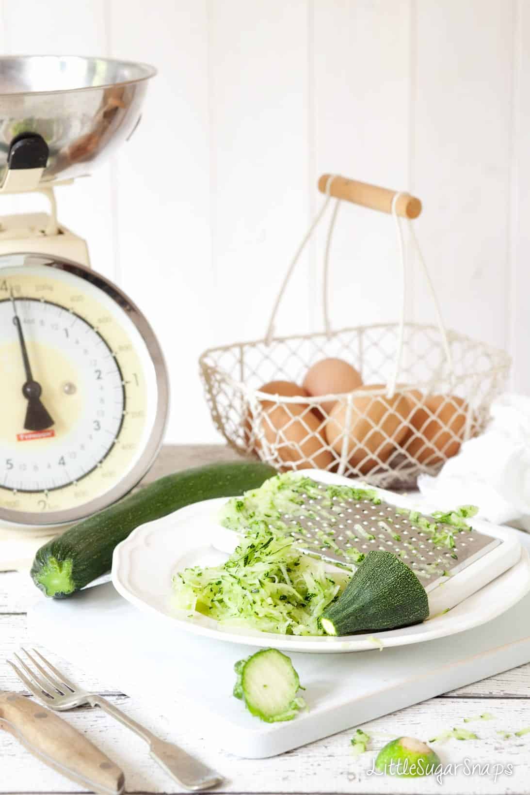 Courgette (zucchini) being grated onto a plate