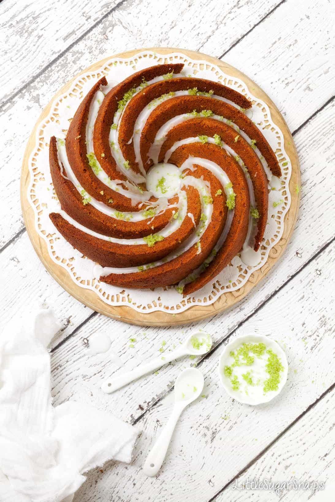 Overhead of a bundt cake topped with water icing and lime zest