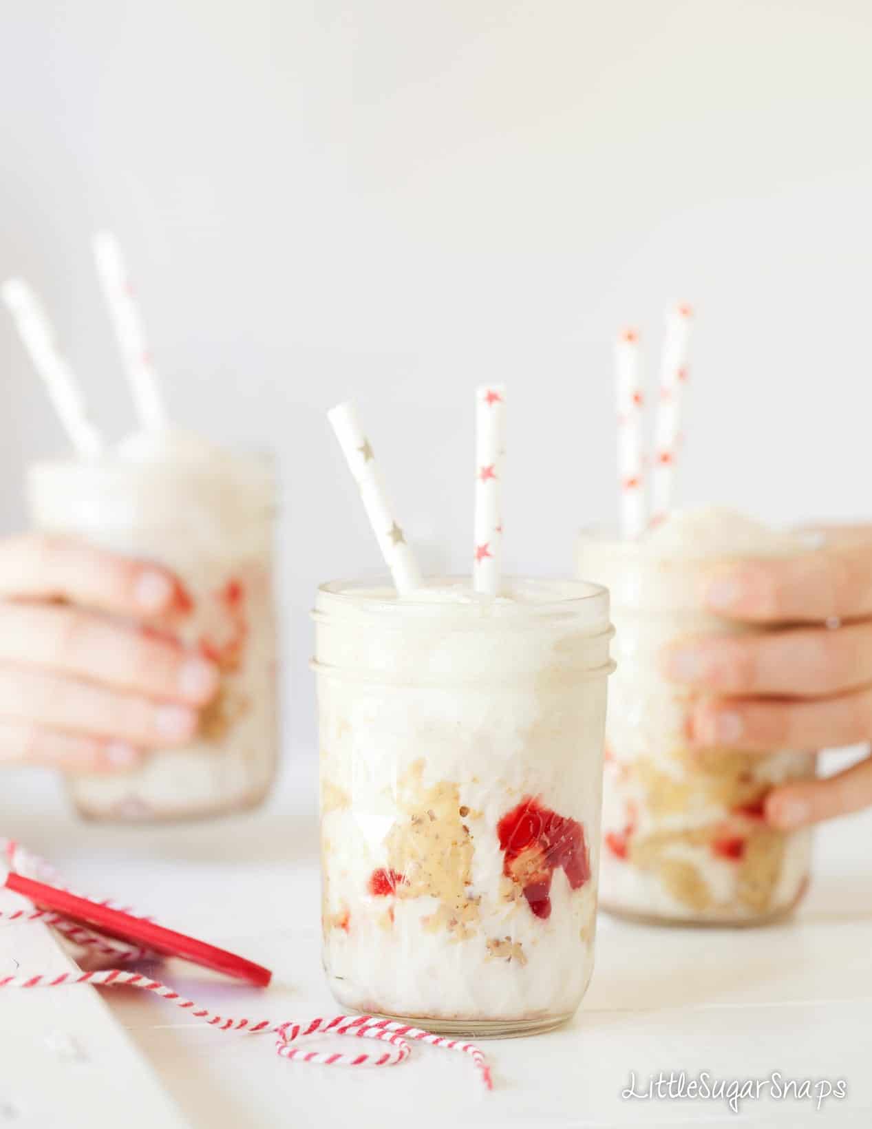 Children taking glasses of Peanut Butter and Jelly Milkshake from a table